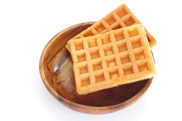 Delicious sweet waffle in wooden bowl on white background