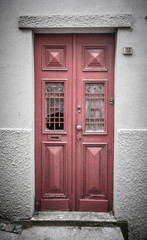 Fototapeta premium Old red wooden door with window and grid. Toned