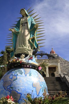 Statue of virgen of Guadalupe over the world