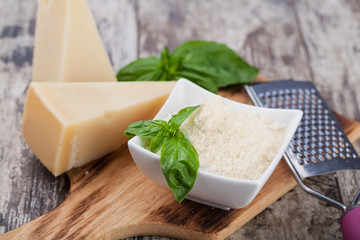 grated parmesan cheese and metal grater on wooden board
