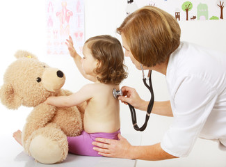 Eine Kinderärztin hört ein Kind mit einem Stethoskop ab