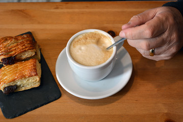 Man's hand  stirring a cappuccino