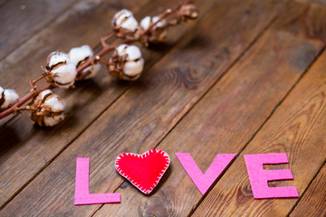 red heart and gossypium on the wooden background
