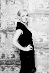 Blonde posing in black dress on background wall black and white