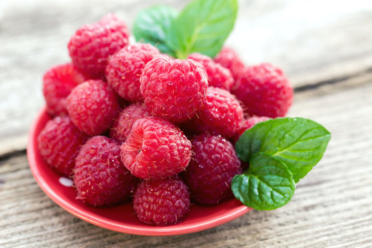 Close-up of ripe raspberries with mint leafs