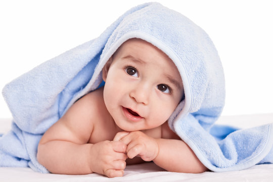 Cute gently baby lying on bed with blue towel