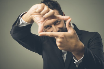 Attractive man framing eyes with fingers