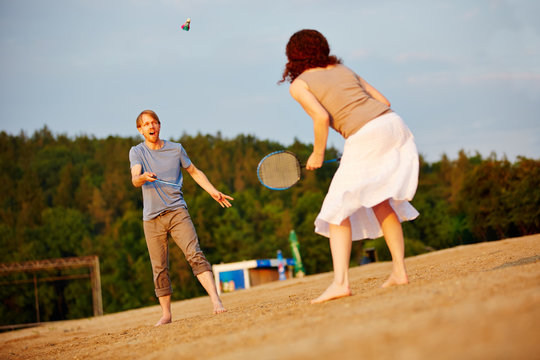Paar spielt Federball am Strand im Sommer
