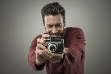 Young man taking pictures with a vintage camera
