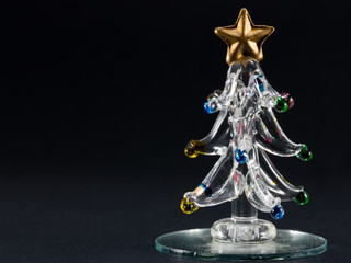 glass christmas tree over black background