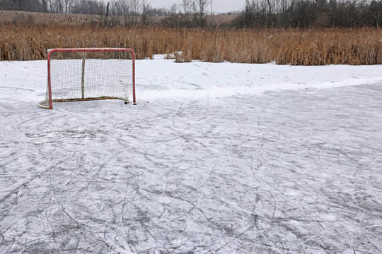 A ice hockey net on an outdoor pond rink..