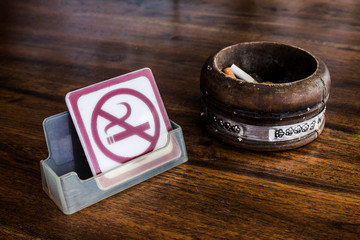 No smoking sign and vintage wood ashtray on table