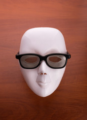 Theater mask in glasses on the table