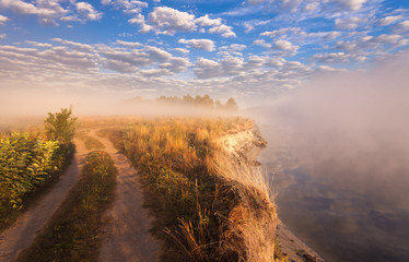 misty morning on the river and clouds reflected in water