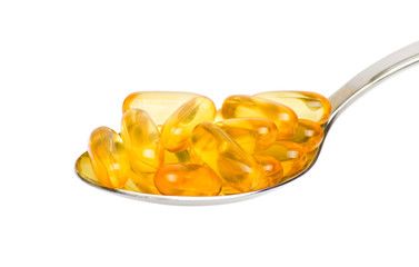 Cod liver oil Omega 3 gel capsules in spoon on white background