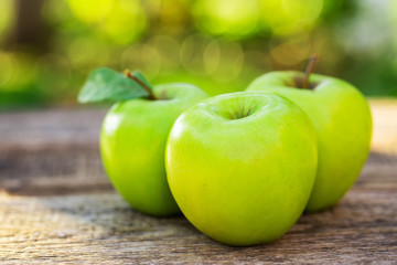 Ripe apples on wooden table, on nature background