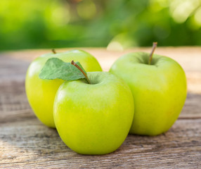 Ripe apples on wooden table, on nature background
