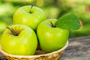 Ripe apples on wooden table, on nature background