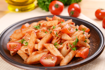 Pasta with tomato sauce on plate on table close-up