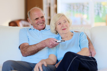 Obraz premium Seniors couple relaxing at home watching tv