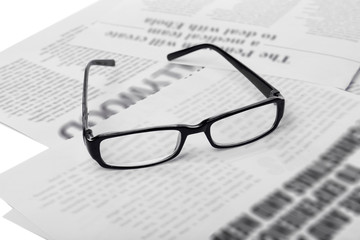 Glasses and newspapers, close-up