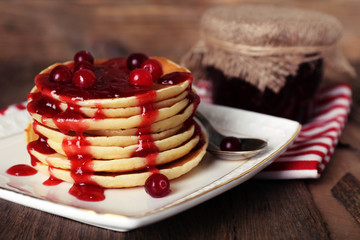Stack of delicious pancakes with cranberries and jam