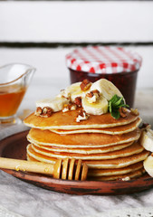 Stack of pancakes with mint, walnuts and slices of banana