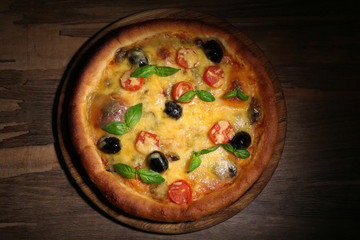 Pizza on board and wooden table background