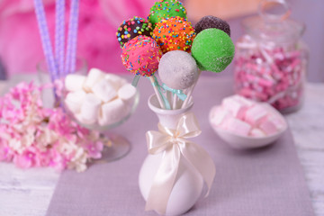 Obraz na płótnie Canvas Sweet cake pops in vase on table on bright background
