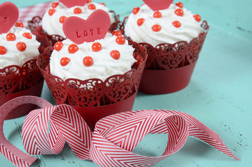 Valentine cupcakes on  green blue wood background.