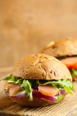 Sandwich with salmon on wooden background