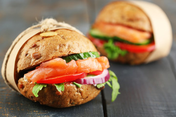 Sandwiches with salmon on wooden background