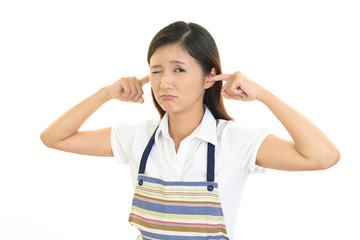 耳をふさぐ女性