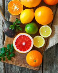 Halves of citrus fruits on wooden background. Orange, grapefruit