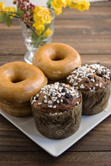 Two stacked sugared donuts and muffins
