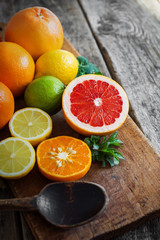 Halves of fresh citrus fruits on wooden background. Orange, grap