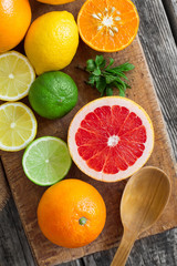 Fototapeta na wymiar Halves of fresh citrus fruits on wooden background. Orange, grap