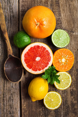 Fototapeta na wymiar Halves of citrus fruits on wooden background. Orange, grapefruit