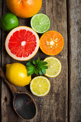 Naklejka na ściany i meble Halves of fresh citrus fruits on wooden background. Orange, grap