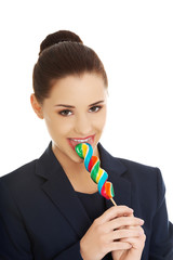 Beautiful businesswoman with lollipop