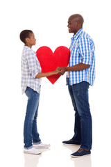 couple holding hands and paper heart symbol