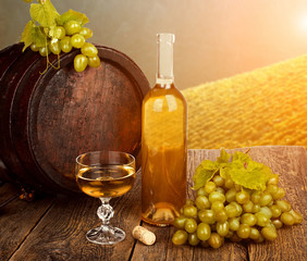 Red wine with old wine barrel on background of vineyard
