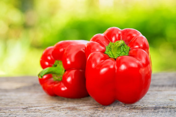 Fresh red pepper on wooden table on nature background