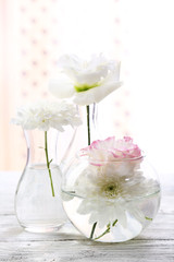 Beautiful flowers in vases with light from window