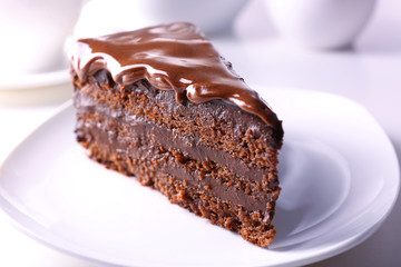 Delicious chocolate cake on plate on table on light background