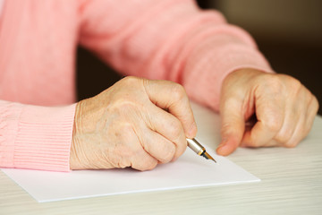 Hands of adult woman writing with pen,