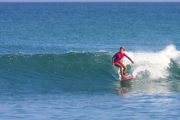 Surfer girl on the wave, Indonesia.