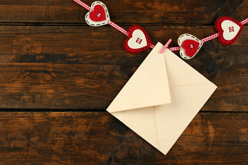 Love letter hanging on rope on rustic wooden background
