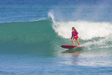 Surfer girl on the wave, Indonesia.