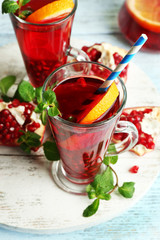Pomegranate drink in glasses with mint and slices of orange
